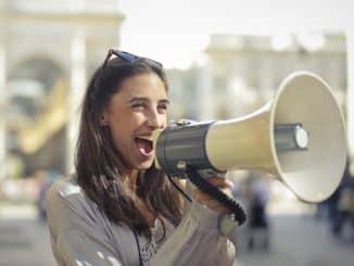 cheerful-young-woman-screaming-into-megaphone-1