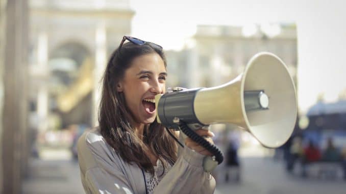 cheerful-young-woman-screaming-into-megaphone-1