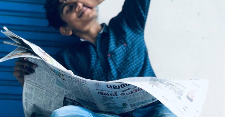 photo-of-a-man-sitting-while-holding-newspaper