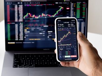 person-checking-stock-market-graphs-on-laptop-and-smartphone-focusing-on-financial-data