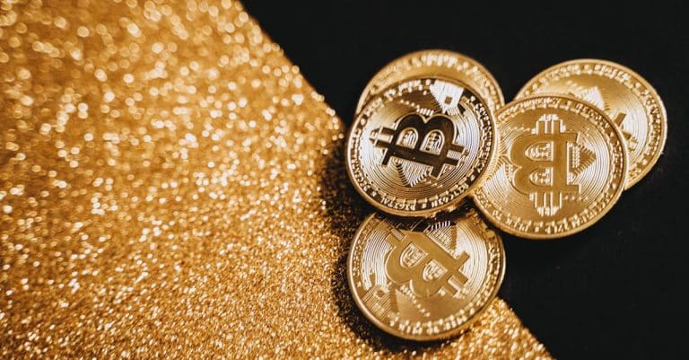 gold-bitcoin-coins-displayed-on-a-sparkling-gold-texture-representing-digital-currency-and-finance